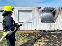 Wohncontainer von Asylunterkunft in Flammen