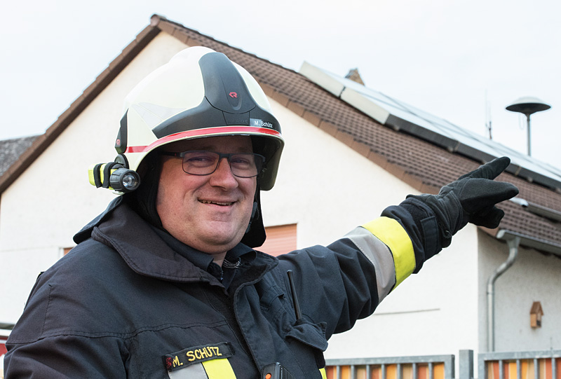 Gemeindebrandinspektor Markus Schütz weist auf die Sirenenprobe in der Gemeinde Brechen am kommenden Samstag gegen 15 Uhr hin / Im Hintergrund zu sehen, die Sirene auf dem Kindergarten in Werschau - © FOTO-EHRLICH.de
