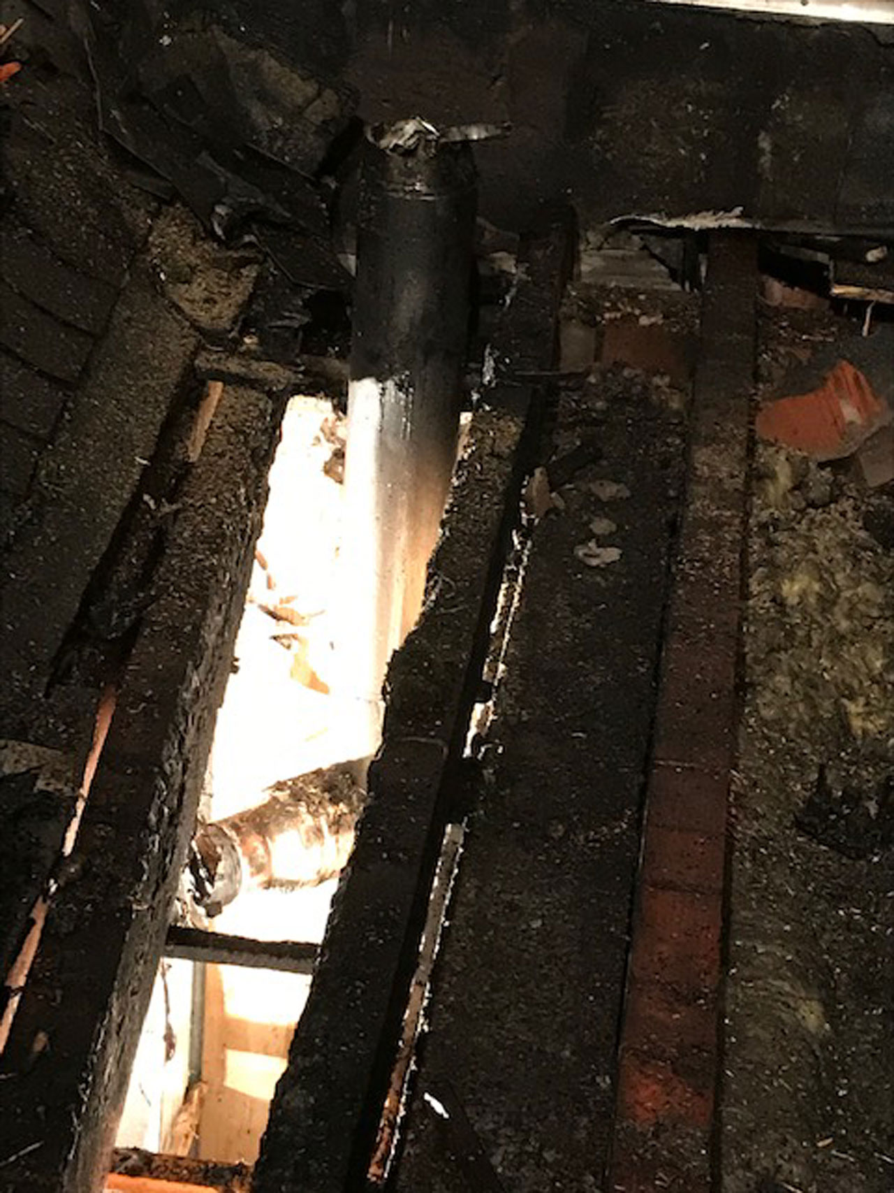 Das Kaminrohr in der Bildmitte führte zum Brand der beiden Balken rechts und links. Das Feuer wanderte danach weiter in die anschließender Bauteile.