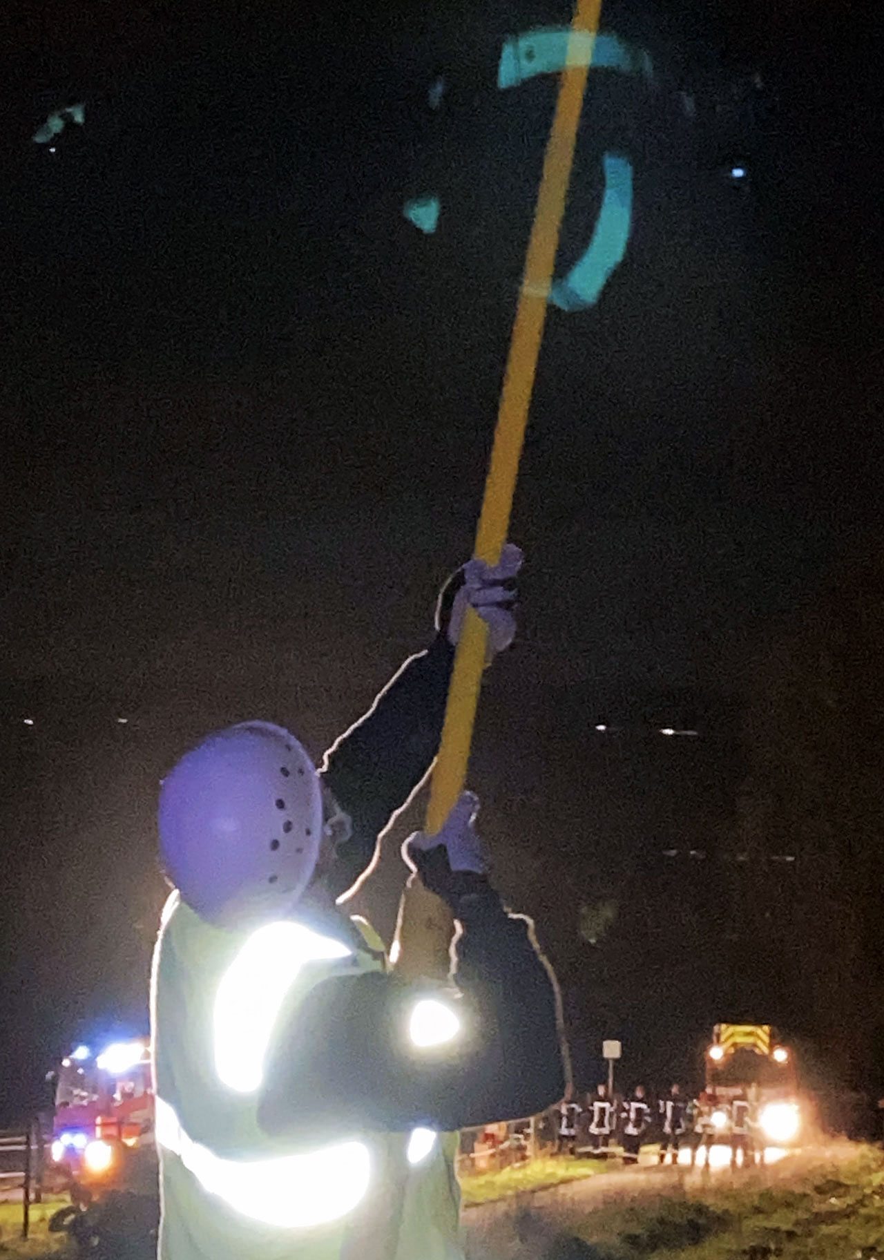 Mitarbeiter der Leitungs-Betreiberfirma erden die abgeschaltete Leitung, damit der Drachen durch die Feuerwehr geborgen werden kann - Fotos: Alexander Rembser (FF Bad Camberg)